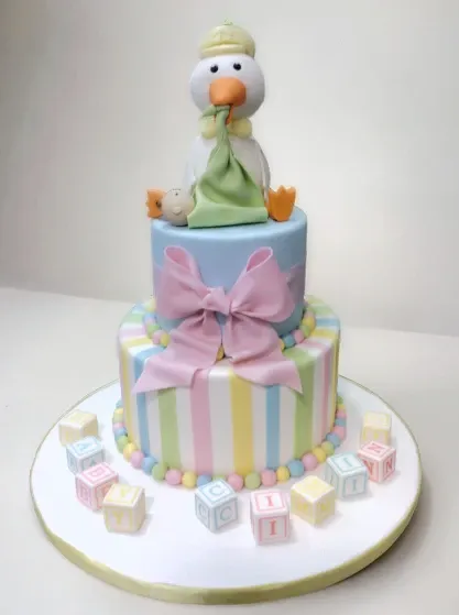cute pastel coloured babies birthday cake with letter blocks and a gumpaste duck topper