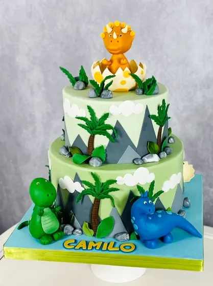 dinosaur themed birthday celebration cake with sculpted dinosaurs